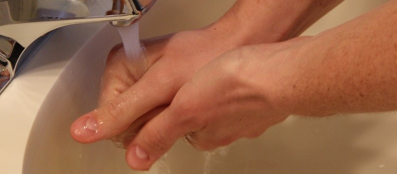 Mains sous le jet d’eau du robinet